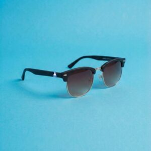 Photo lunettes de soleil modèle Emboucaneur de couleur noir profond, présentées sur un fond bleu azur éclatant, collection Chouchou Beignet Marseille.