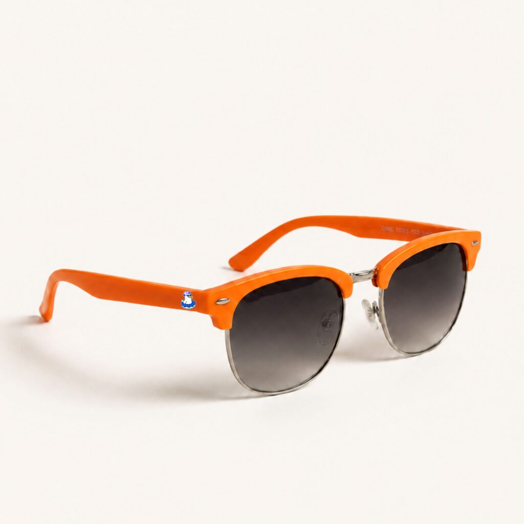 Lunettes de soleil femme au style Clubmaster tendance, avec une monture supérieure en acétate orange vif et une structure inférieure en métal argenté. Les verres présentent une teinte dégradée sombre. Sur la branche gauche, on distingue le logo Chouchou Beignet représentant un goéland avec une bouée. Cet accessoire plage de la collection été Marseille est photographié de trois-quarts sur un fond blanc uni et épuré.