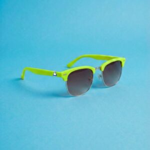 Photo lunettes de soleil modèle Emboucaneur de couleur vert pomme, présentées sur un fond bleu azur éclatant, collection Chouchou Beignet Marseille.