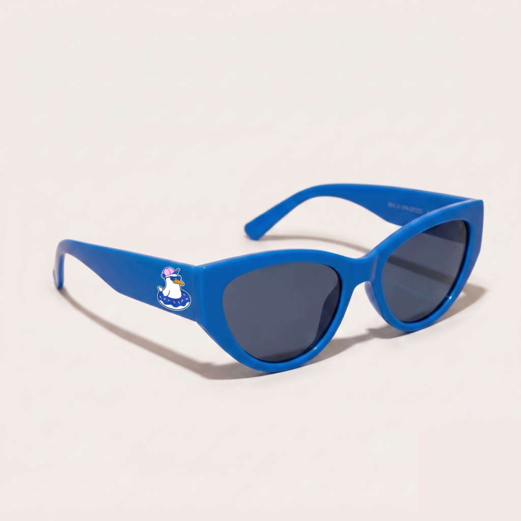 Lunettes de soleil femme au design tendance avec monture en plastique bleu azur et forme cat-eye, verres gris foncé, posées sur fond clair minimaliste, logo Chouchou Beignet sur la branche, accessoire plage de la collection été Marseille.
