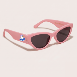Lunettes de soleil femme tendance avec monture en plastique rose bonbon et forme cat-eye, verres gris foncé, posées sur fond clair minimaliste, logo Chouchou Beignet sur la branche, accessoire plage de la collection été Marseille.