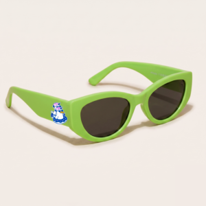 Lunettes de soleil femme tendance avec monture en plastique vert pomme et forme cat-eye, verres gris foncé, posées sur fond clair minimaliste, logo Chouchou Beignet sur la branche, accessoire plage de la collection été Marseille.