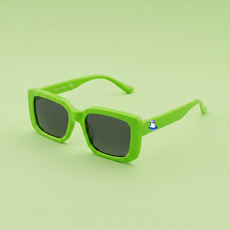 Photo lunettes de soleil modèle Droitaubut de couleur vert pomme avec le logo Chouchou Beignet sur la branche, présentées sur un fond vert coordonné, collection Chouchou Beignet Marseille.