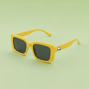 Photo lunettes de soleil modèle Fada de couleur jaune soleil, présentées sur un fond vert éclatant, collection Chouchou Beignet Marseille.