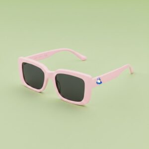 Photo lunettes de soleil modèle Fada de couleur rose bonbon, présentées sur un fond vert éclatant, collection Chouchou Beignet Marseille.