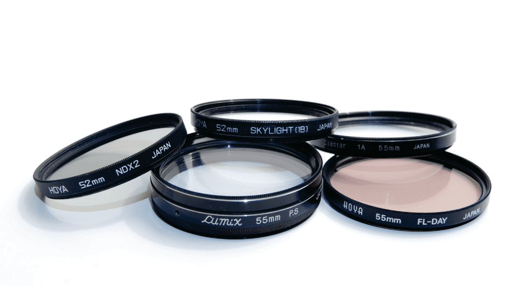 Ensemble de filtres optiques circulaires de marques Hoya et Lumix, incluant des modèles NDX2 et Skylight, posés sur un fond blanc.