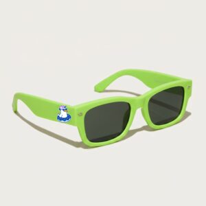 Une photo d'accessoire plage prise de trois quarts face montre une paire de lunettes de soleil femme tendance de style wayfarer. La monture épaisse est en acétate mat de couleur vert pomme éclatant. Les verres sont gris foncé, presque noirs. Sur la branche gauche, on voit clairement le logo Chouchou Beignet représentant un goéland coiffé d'une casquette et flottant dans une bouée. Le fond de la photo est un blanc crème très épuré. Ces lunettes font partie de la collection été Marseille.
