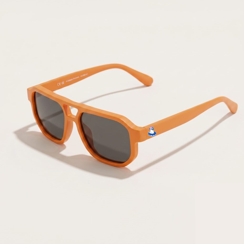 Lunettes de soleil au style aviateur revisité et tendance, se caractérisant par une monture épaisse à double pont en acétate mat de couleur orange vif. Les verres foncés affichent une teinte gris-noir hautement protectrice. Présenté de trois-quarts face sur un fond blanc crème très épuré avec une ombre portée légère, cet accessoire plage met en avant le logo Chouchou Beignet avec son gabian en bouée sur la branche gauche, une pièce maîtresse pour la collection été Marseille.
