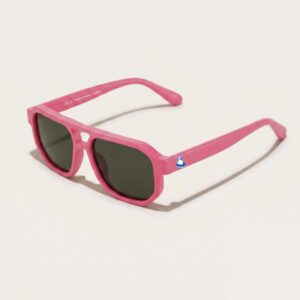 Lunettes de soleil au style aviateur revisité et tendance, se caractérisant par une monture épaisse à double pont en acétate mat de couleur rose bonbon. Les verres foncés affichent une teinte gris-vert hautement protectrice. Présenté de trois-quarts face sur un fond blanc crème très épuré avec une ombre portée légère, cet accessoire plage met en avant le logo Chouchou Beignet avec son gabian en bouée sur la branche gauche, une pièce maîtresse pour la collection été Marseille.